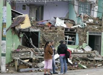 Archivo:Familia frente casa destruida.jpg