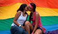 Dos Bolivianas Liberadas junto A la bandera LGTB