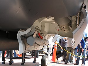 Close-up view of open aircraft weapons bay. The aircraft mock-up itself is on display, watched on by onlookers