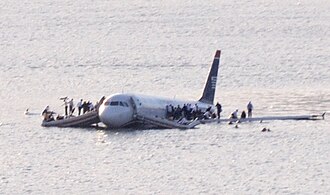 A soggy Airbus A320 making an unscheduled swim, with people chilling on its wings like it’s a party raft