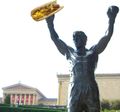 Rocky Balboa eating a cheesesteak