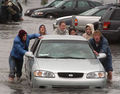 Redwood High School students push a car from a flooded parking lot at the Larkspur California.jpg